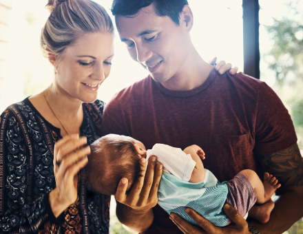 A young couple holding their baby.