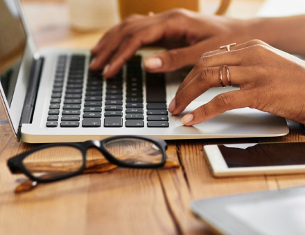 Hands typing on a laptop.